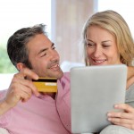 Couple sitting in sofa at home and doing online shopping